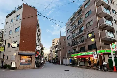 an empty street in a city with tall buildings at Hananoie\u83ef\u4e4b\u5bb6 in Tokyo