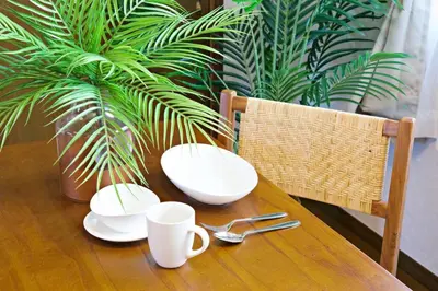 a wooden table with two plates and cups on it at NH Buil 7F in Tokyo