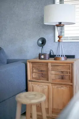 a lamp on a wooden dresser next to a couch at \u3077\u3075\u304b\u5927\u5cf6 in Tokyo