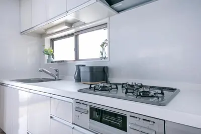a white kitchen with a stove and a sink at \u3077\u3075\u304b\u5927\u5cf6 in Tokyo