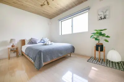a white bedroom with a bed and a window at \u3077\u3075\u304b\u5927\u5cf6 in Tokyo
