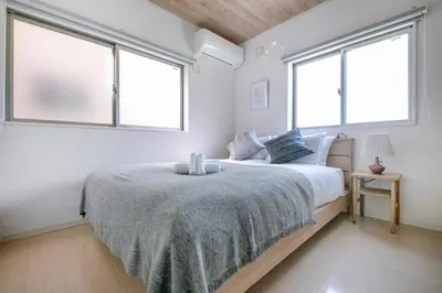 a bedroom with a large bed with two windows at \u3077\u3075\u304b\u5927\u5cf6 in Tokyo