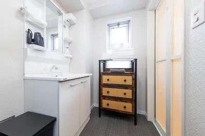 a small bathroom with a sink and a mirror at \u30db\u30b9\u30c6\u30eb\u30a2\u30df\u30fc\u30c1 Hostel Amici in Tokyo