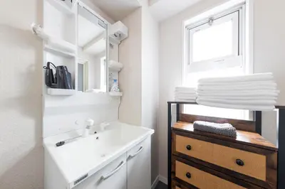 a bathroom with a sink and a mirror at \u30db\u30b9\u30c6\u30eb\u30a2\u30df\u30fc\u30c1 Hostel Amici in Tokyo