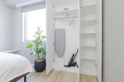 a bedroom with a white closet with a mirror at \u30db\u30b9\u30c6\u30eb\u30a2\u30df\u30fc\u30c1 Hostel Amici in Tokyo