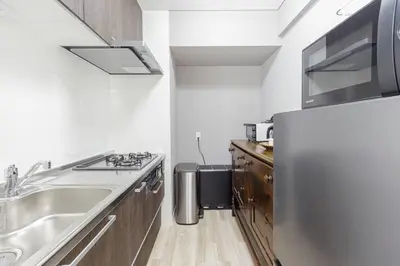 a kitchen with a stainless steel refrigerator and a sink at \u30db\u30b9\u30c6\u30eb\u30a2\u30df\u30fc\u30c1 Hostel Amici in Tokyo