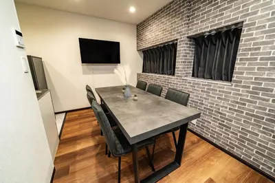 a dining room with a table and a brick wall at 90, Yotsugi-A, private house rental, \u30ef\u30f3\u30d3\u30ec\u30c3\u30b8\u56db\u3064\u6728 in Tokyo