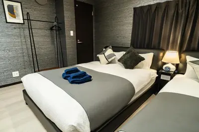 a bedroom with two beds with a blue towel on them at 90, Yotsugi-A, private house rental, \u30ef\u30f3\u30d3\u30ec\u30c3\u30b8\u56db\u3064\u6728 in Tokyo