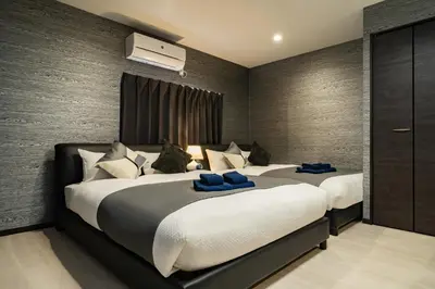 a bedroom with two beds with blue pillows at 90, Yotsugi-A, private house rental, \u30ef\u30f3\u30d3\u30ec\u30c3\u30b8\u56db\u3064\u6728 in Tokyo