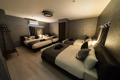 a hotel room with two beds and a couch at 90, Yotsugi-A, private house rental, \u30ef\u30f3\u30d3\u30ec\u30c3\u30b8\u56db\u3064\u6728 in Tokyo