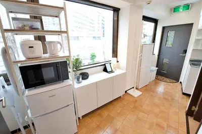 a living room with a tv and a large window at \u30ea\u30de\u30fc\u30eb\u30d3\u30eb2 401 in Tokyo