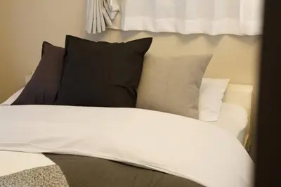 a bed with black and white pillows on it at \u30ea\u30de\u30fc\u30eb\u30d3\u30eb2 401 in Tokyo