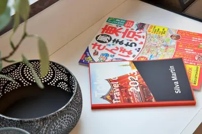 a table with books and a vase and a book at \u30ea\u30de\u30fc\u30eb\u30d3\u30eb2 401 in Tokyo