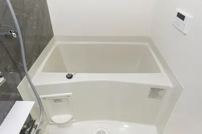 a white bath tub with a shower in a bathroom at G-Stage 01 IKEBUKURO by Tranova in Tokyo