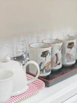 a group of coffee cups on a shelf at SunshineHouse \u5411\u5cf6 in Tokyo