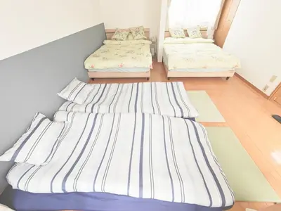 two twin beds in a room with ainylinylinylinylinyl at SunshineHouse \u5411\u5cf6 in Tokyo