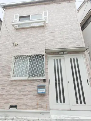 a brick house with a white door and a window at SunshineHouse \u5411\u5cf6 in Tokyo