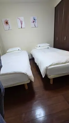 two beds in a room with pictures on the wall at MEZON DE OAK Shin-Okubo in Tokyo