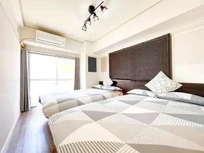 a bedroom with two beds and a window at Kuramae HK 501 in Tokyo