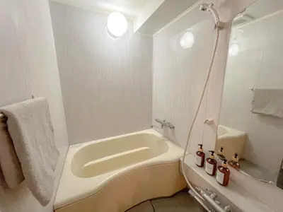 a white bathroom with a tub and a sink at Kuramae HK 501 in Tokyo