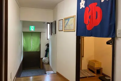 a hallway with a green door and a green exit sign at Konoha House - Vacation STAY 11581v in Tokyo