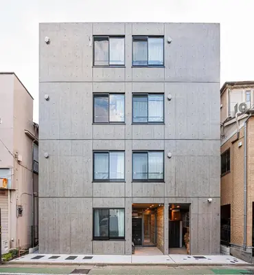 a concrete building with windows on a street at 67 Apt \u677f\u6a4b\u672c\u753a in Tokyo