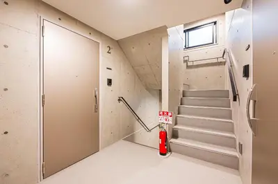a room with a staircase with a fire hydrant and a door at 67 Apt \u677f\u6a4b\u672c\u753a in Tokyo