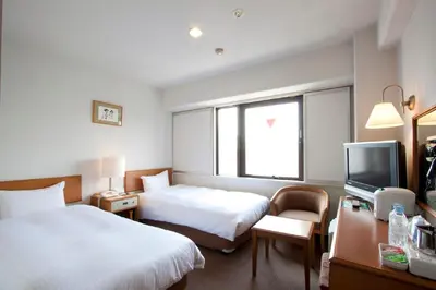 a hotel room with two beds and a television at Smile Hotel Sugamo in Tokyo
