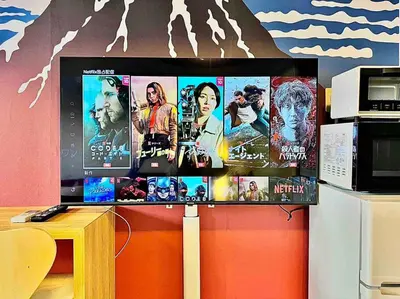 a computer monitor with movies on it on a table at Hokusai's House Shibuya Dogenzaka 311 in Tokyo