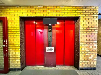 two red doors in a brick building with a sign on it at Hokusai's House Shibuya Dogenzaka 311 in Tokyo
