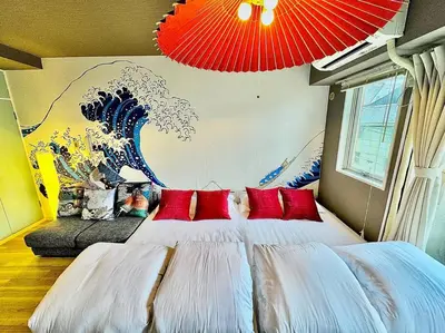 a bedroom with a large bed with red pillows at Hokusai's House Shibuya Dogenzaka 311 in Tokyo
