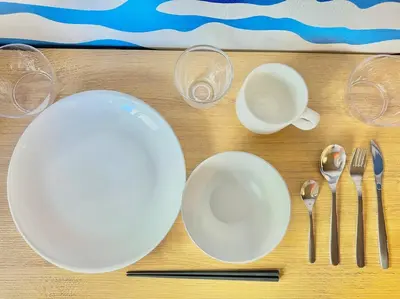 a table with white plates and wine glasses and silverware at Hokusai's House Shibuya Dogenzaka 311 in Tokyo
