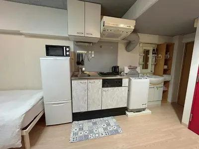 a small kitchen with a refrigerator and a sink at Ueno Iriya Hotel in Tokyo