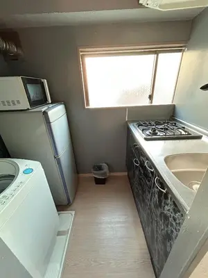 a small kitchen with a stove and a sink at Ueno Iriya Hotel in Tokyo