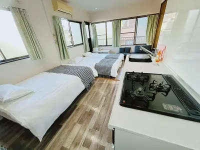 a room with three beds and a tv in it at Ueno Iriya Hotel in Tokyo