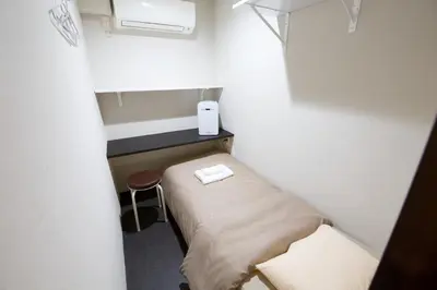 a small room with a bed and a stool in it at smart room tokyo koiwa city in Tokyo