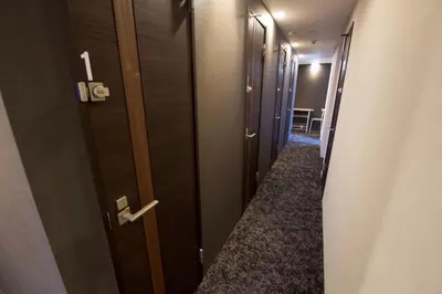 a hallway with a row of doors in a room at smart room tokyo koiwa city in Tokyo