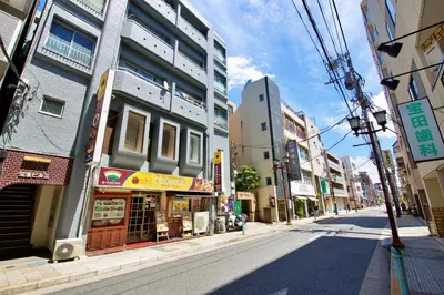 an empty street in a city with tall buildings at smart room tokyo koiwa city in Tokyo