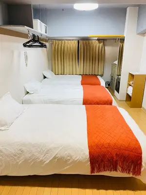 a bedroom with two beds with an orange blanket at Ueno Hotel Palazetto Iriya in Tokyo