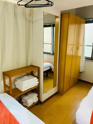 a room with a mirror and a bed and a closet at Ueno Hotel Palazetto Iriya in Tokyo