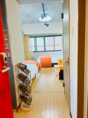 a room with a bed and a bed and a room with a door at Ueno Hotel Palazetto Iriya in Tokyo