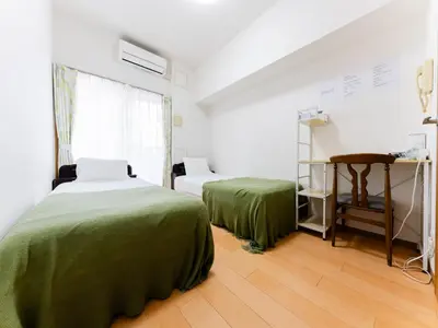 a room with two beds and a table in it at Shin-Okubo Sta・1 min walk/　Shinjuku sta 2min/　Switch in Tokyo