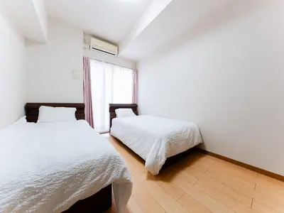 a bedroom with two beds and a window at Shin-Okubo Sta・1 min walk/　Shinjuku sta 2min/　Switch in Tokyo