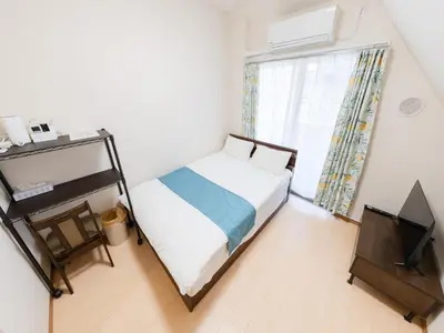 a bedroom with a bed and a television and a window at Shinjuku/Shin-Okubo Sta 2min walk/Kabukicho 5 min in Tokyo