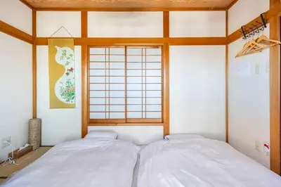 two white beds in a room with a window at \u30a2\u30f3\u30c9\u30b9\u30c6\u30a4\u7530\u7aef\uff16\u4e01\u76ee in Tokyo