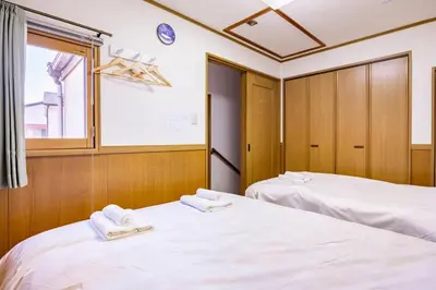 two white beds in a room with a window at \u30a2\u30f3\u30c9\u30b9\u30c6\u30a4\u7530\u7aef\uff16\u4e01\u76ee in Tokyo