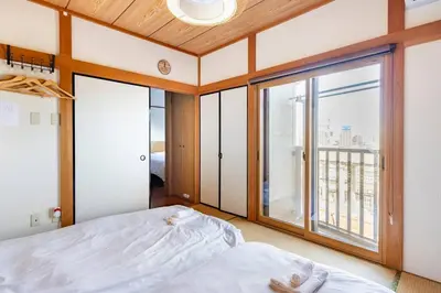 a bedroom with a bed and a large window at \u30a2\u30f3\u30c9\u30b9\u30c6\u30a4\u7530\u7aef\uff16\u4e01\u76ee in Tokyo