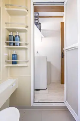 a bathroom with an open door to a refrigerator at \u30a2\u30f3\u30c9\u30b9\u30c6\u30a4\u7530\u7aef\uff16\u4e01\u76ee in Tokyo