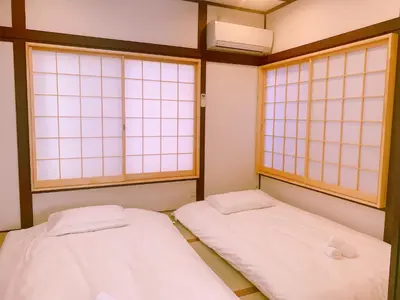 two beds in a room with two windows at miki I in Tokyo