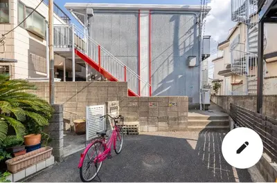 a pink bike parked in front of a building at Momo palace in Tokyo
